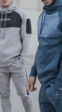 Torso de un hombre con una sudadera de picsil azul con capucha