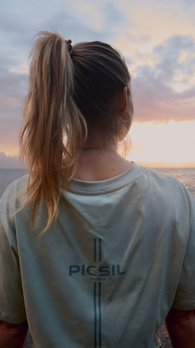 Mujer de espalda con una coleta y una camiseta corta de picsil